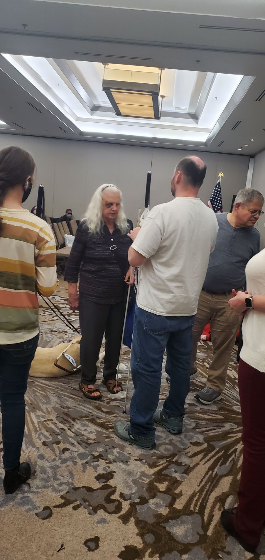A group of people are standing in a room talking to each other.
