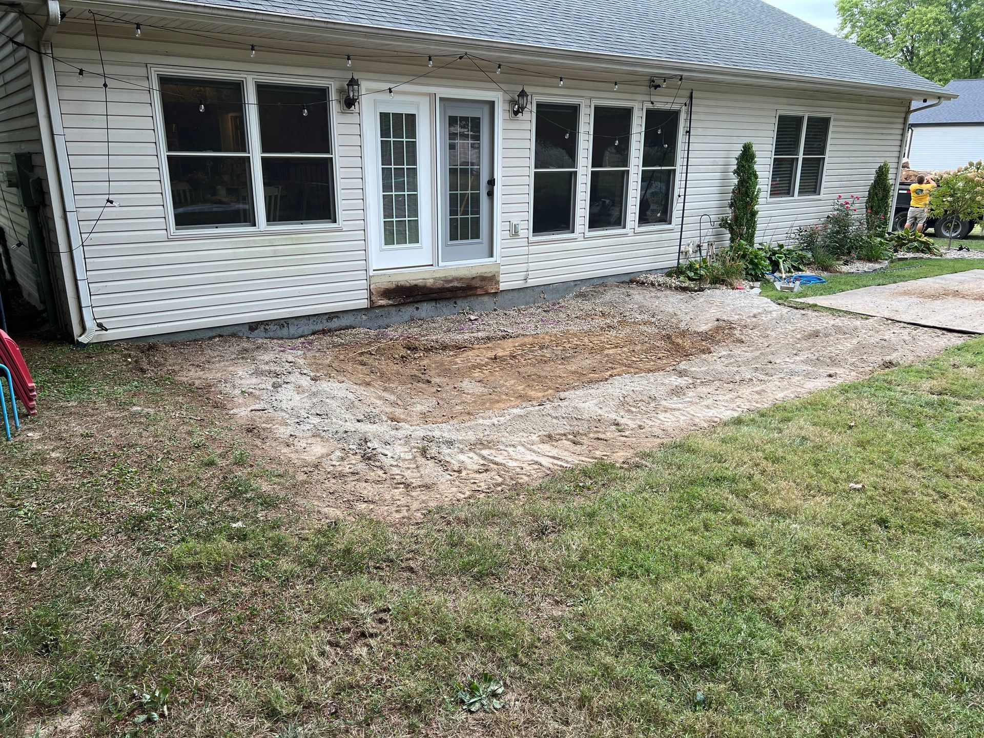 White house exterior with a dirt patch and grass in the front yard