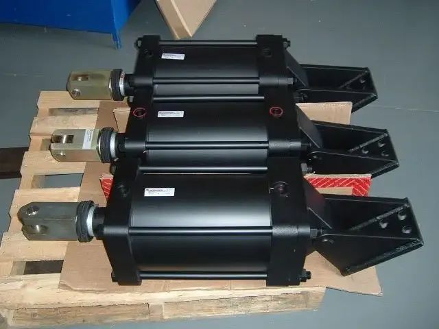 Three Black Hydraulic Cylinders on a Wooden Pallet; Each Has a Bracket — Alloway Hydraulics in Mount Saint John, QLD