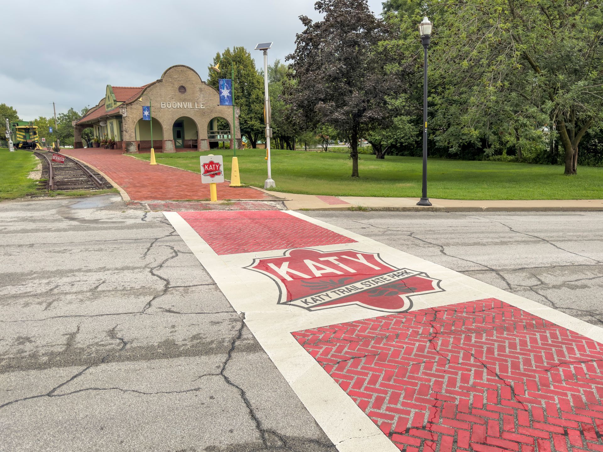 University entrance with red KSU crosswalk leading to a brick building and green lawn