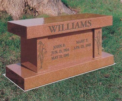 Brown engraved cemetery headstone with the surname Williams on a grassy lawn