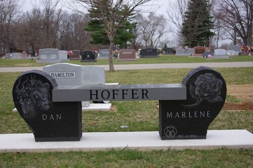 Black granite memorial bench in a cemetery with the names Dan and Marlene Hoffer.