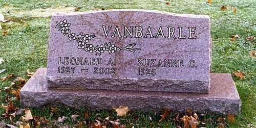 Purple stone gravestone on grass with engraved name and dates.