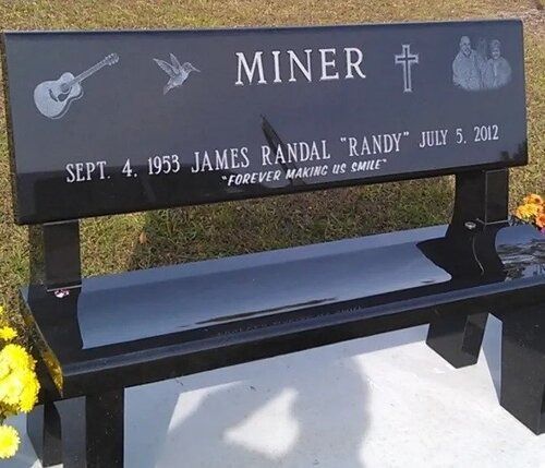 Black memorial bench and gravestone for James Randal “Randy” Miner with dates and guitar engraving.