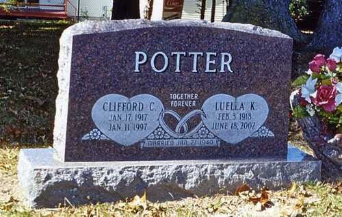 Potter family gravestone with two oval plaques and flowers beside it in a cemetery