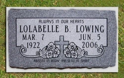 Gray gravestone plaque with floral engraving and the inscription “Always in our hearts,” for Lolabelle B. Lowing.