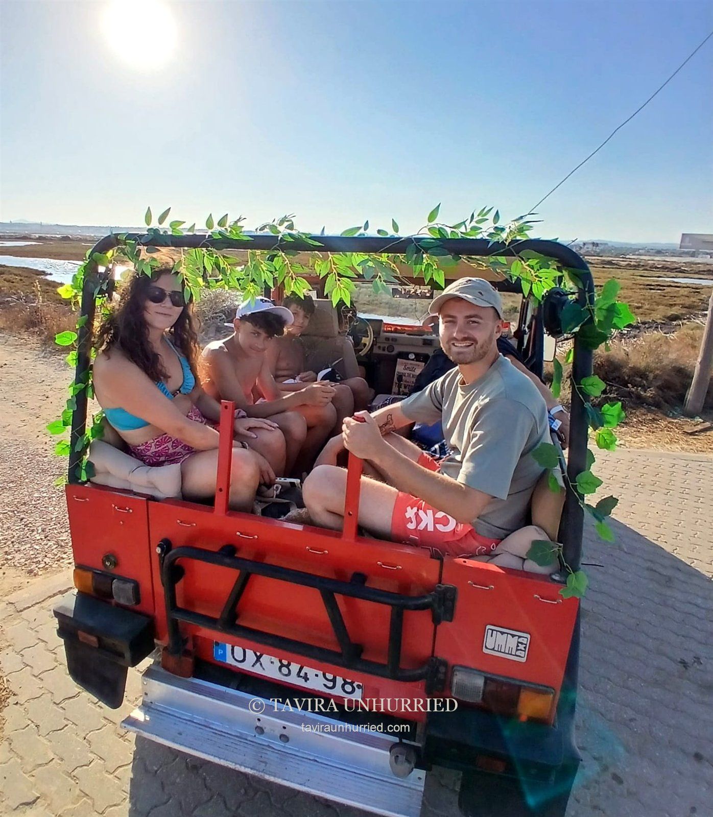 Guests aboard the open-top red UMM jeep on a Tavira Unhurried tour.