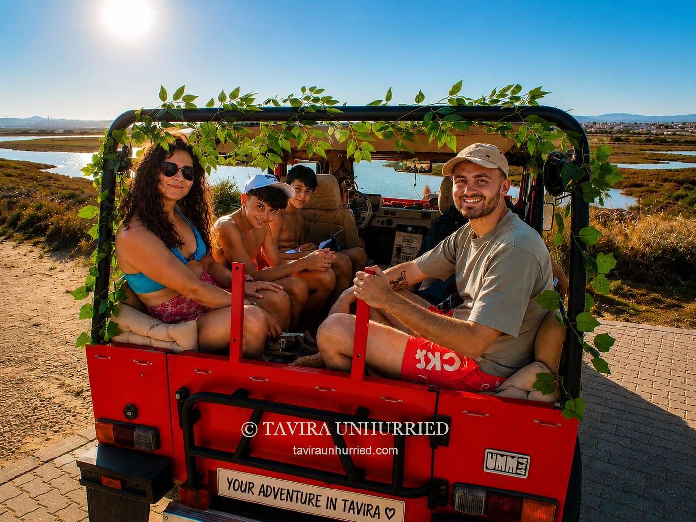 Guests aboard our red Portuguese UMM open-top jeep beside Tavira's salt pans