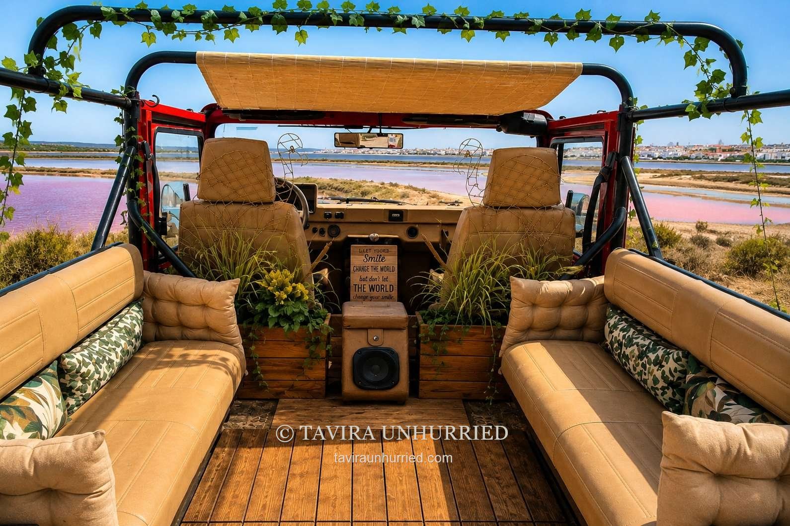 Inside our open-top UMM: tan side benches, wooden floor and a view towards the front seats
