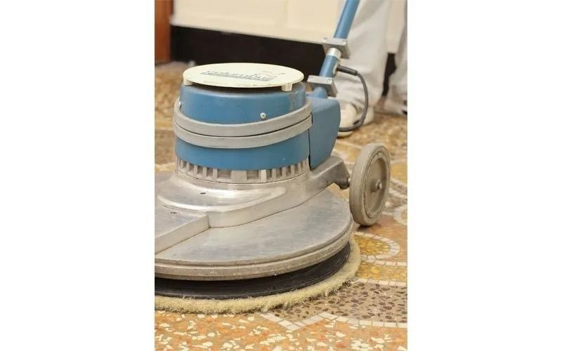 Lucidatrice per pavimenti blu e argento che pulisce un pavimento in piastrelle decorate.
