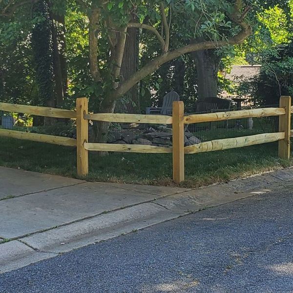 A wooden fence is sitting on the side of a road.