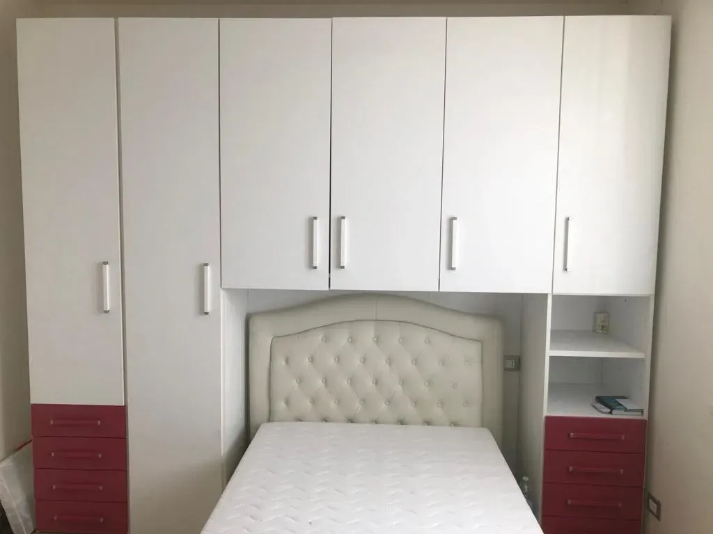 Una camera da letto con letto, armadi, cassettiera e materasso.