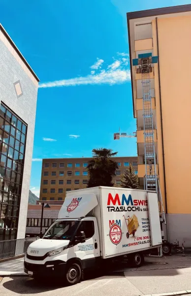 Un camion bianco è parcheggiato davanti a un edificio.