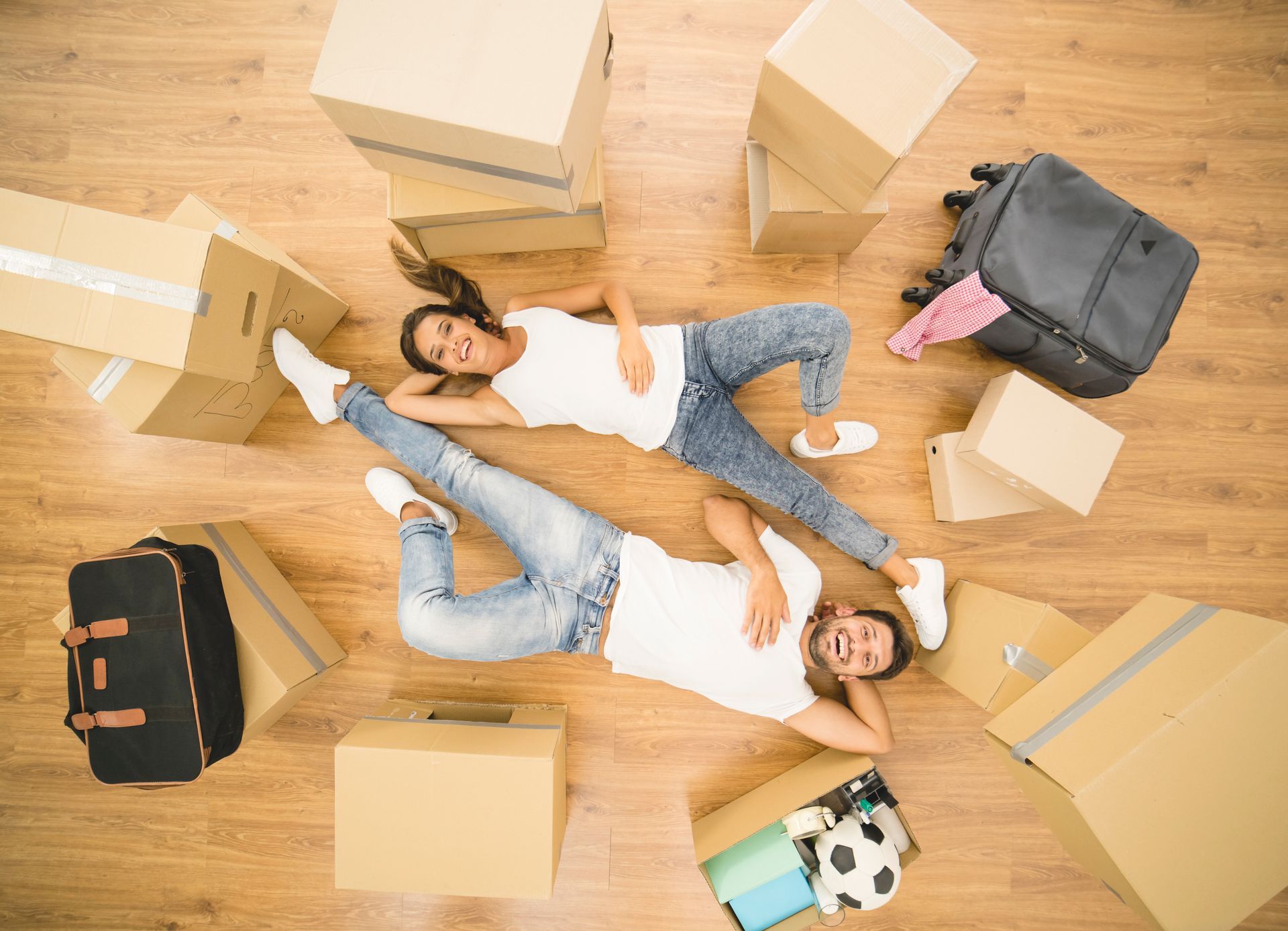 Due donne sono distese sul pavimento circondate da scatole di cartone.