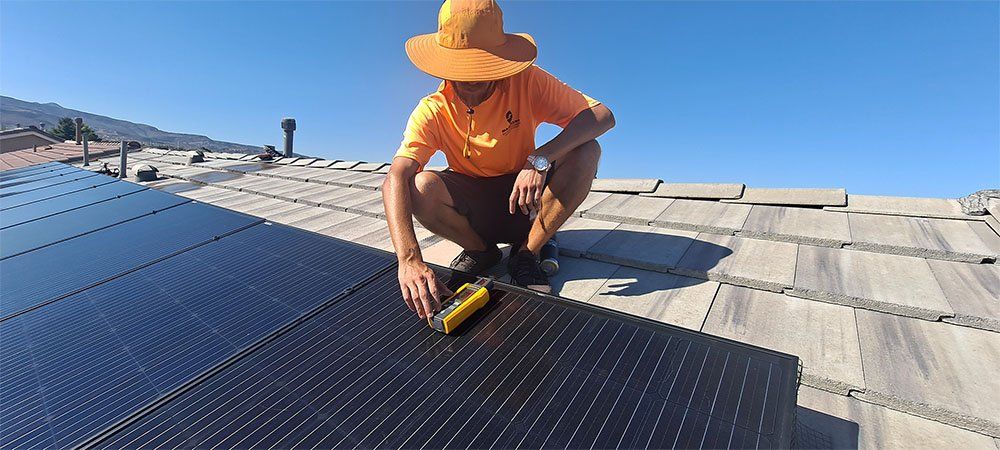 Worker measuring heat in a solar panel