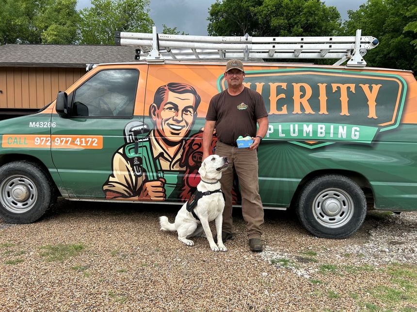 A green and orange van with a plumber and a dog on the side.