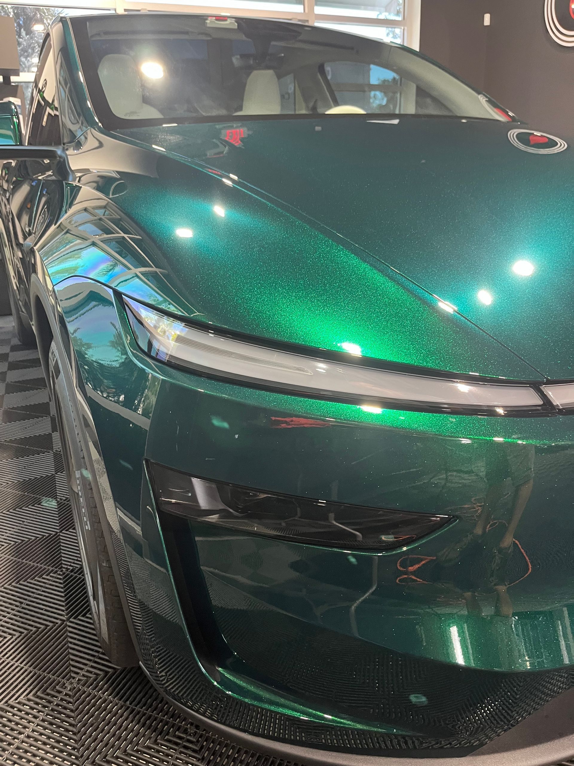Shiny green sports car front view in a showroom under bright lights