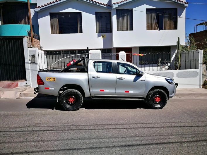 Camioneta plateada aparcada en una calle frente a casas blancas