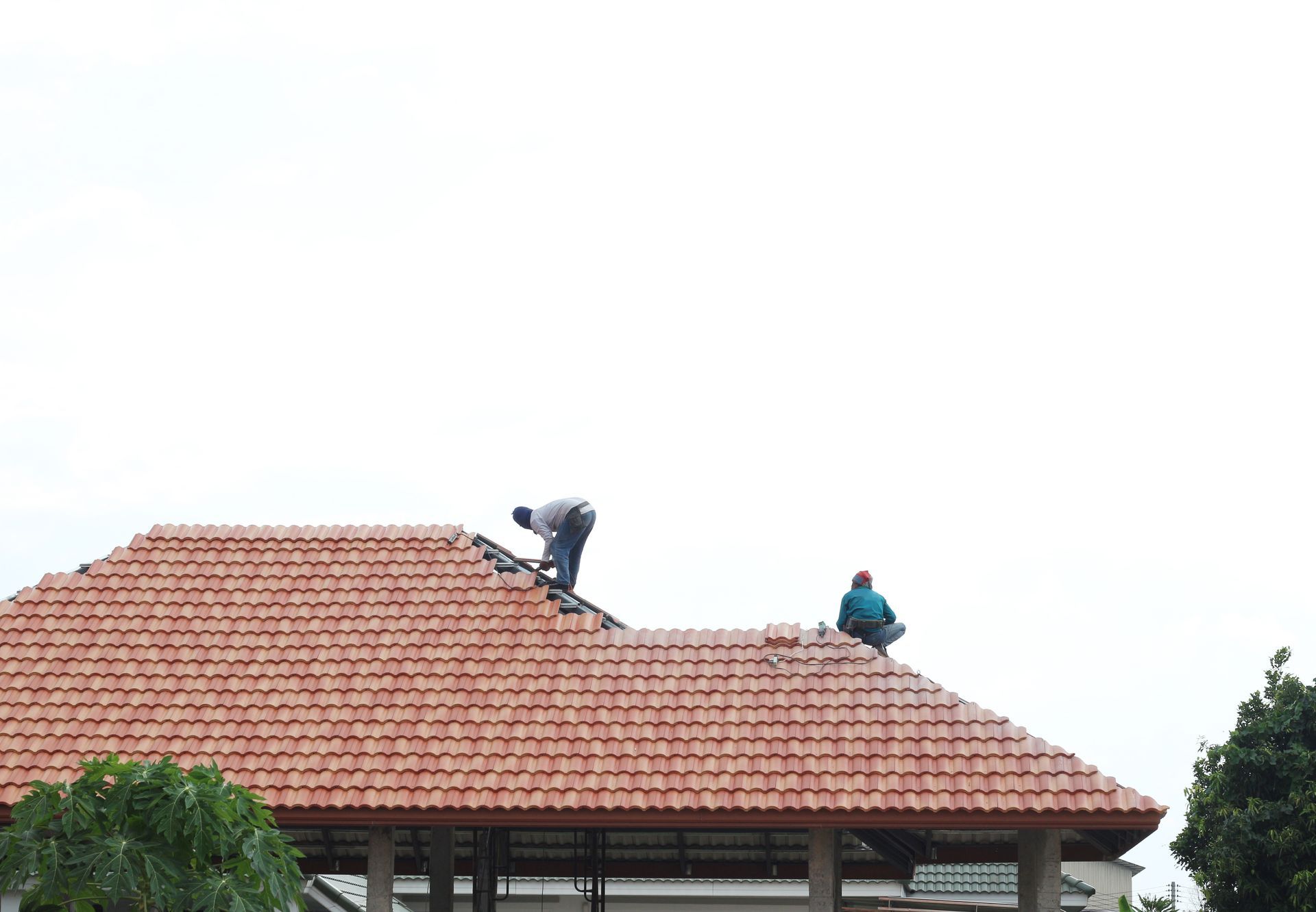 handyman using nail gun to install shingle to repair roof.