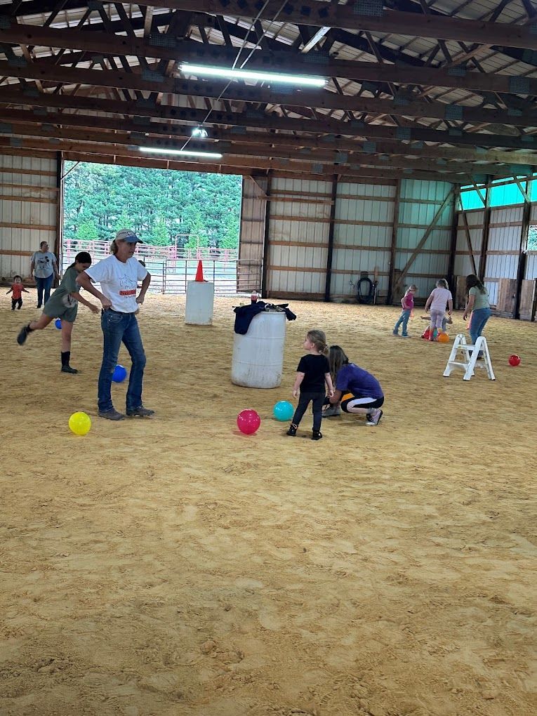 A group of people are playing with balls in a barn.