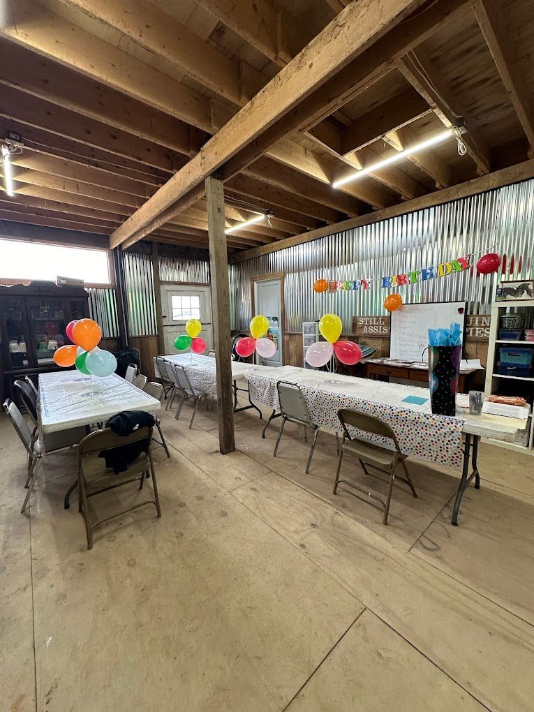A room filled with tables and chairs decorated with balloons.