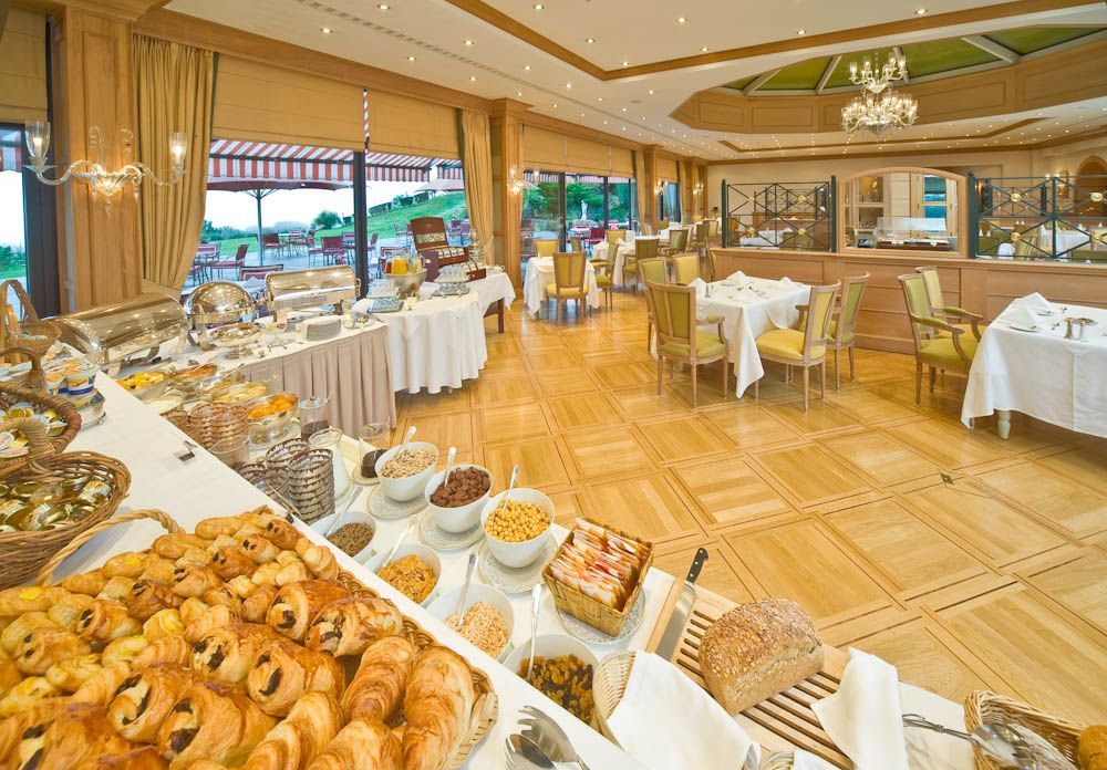 Buffet de viennoiseries et de céréales dans une salle à manger lumineuse. Les portes ouvertes donnant sur le paysage.