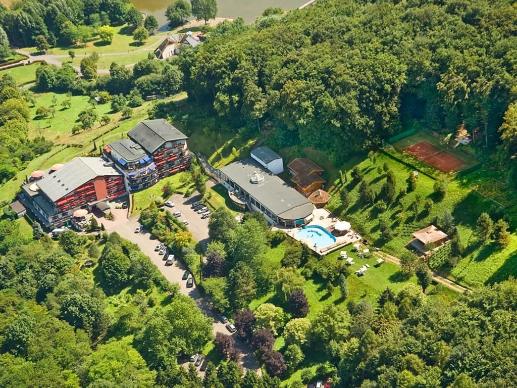 Vue aérienne d'un complexe hôtelier niché dans une forêt verdoyante luxuriante.