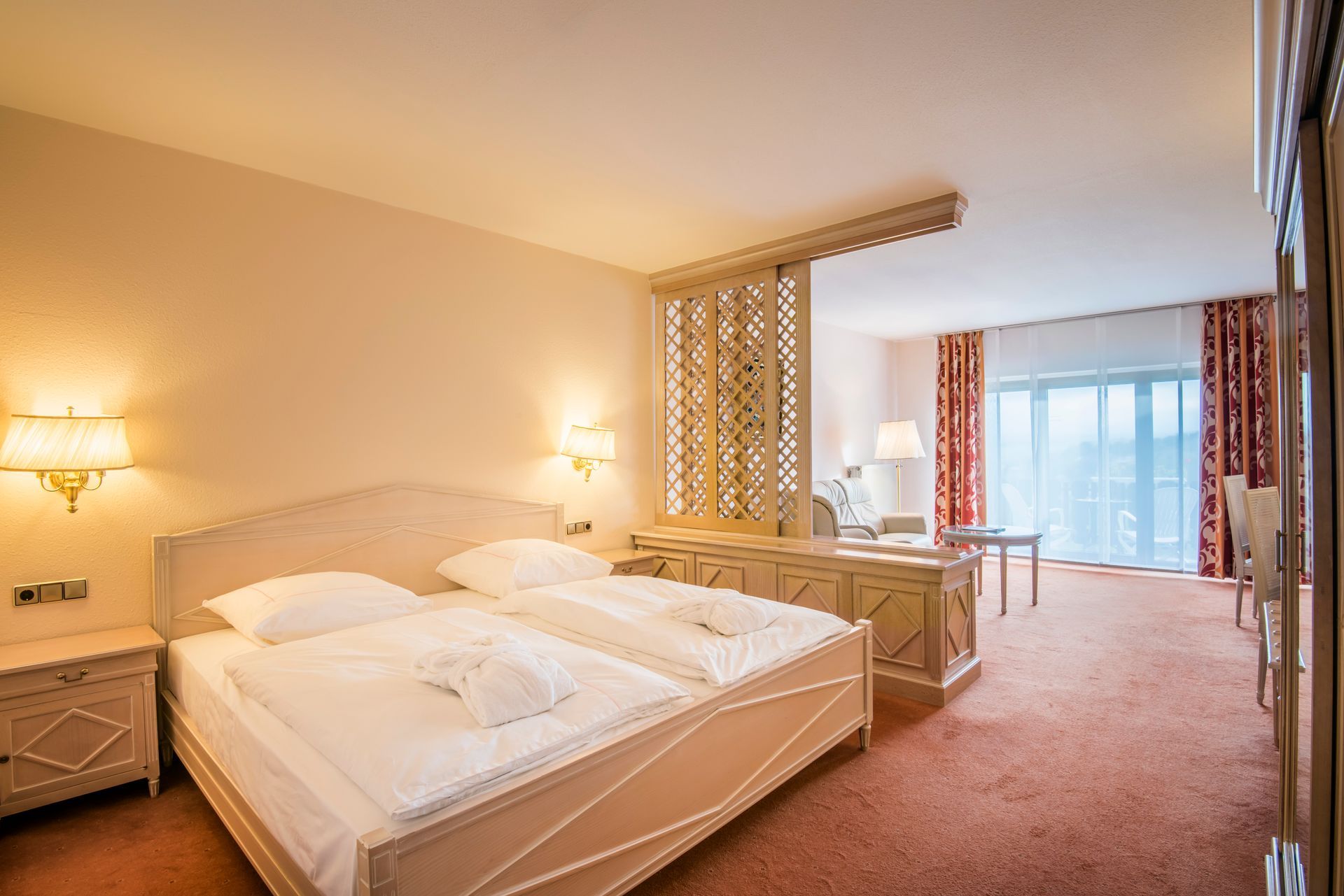 Chambre d'hôtel avec un lit king-size, un bureau et un balcon avec vue.