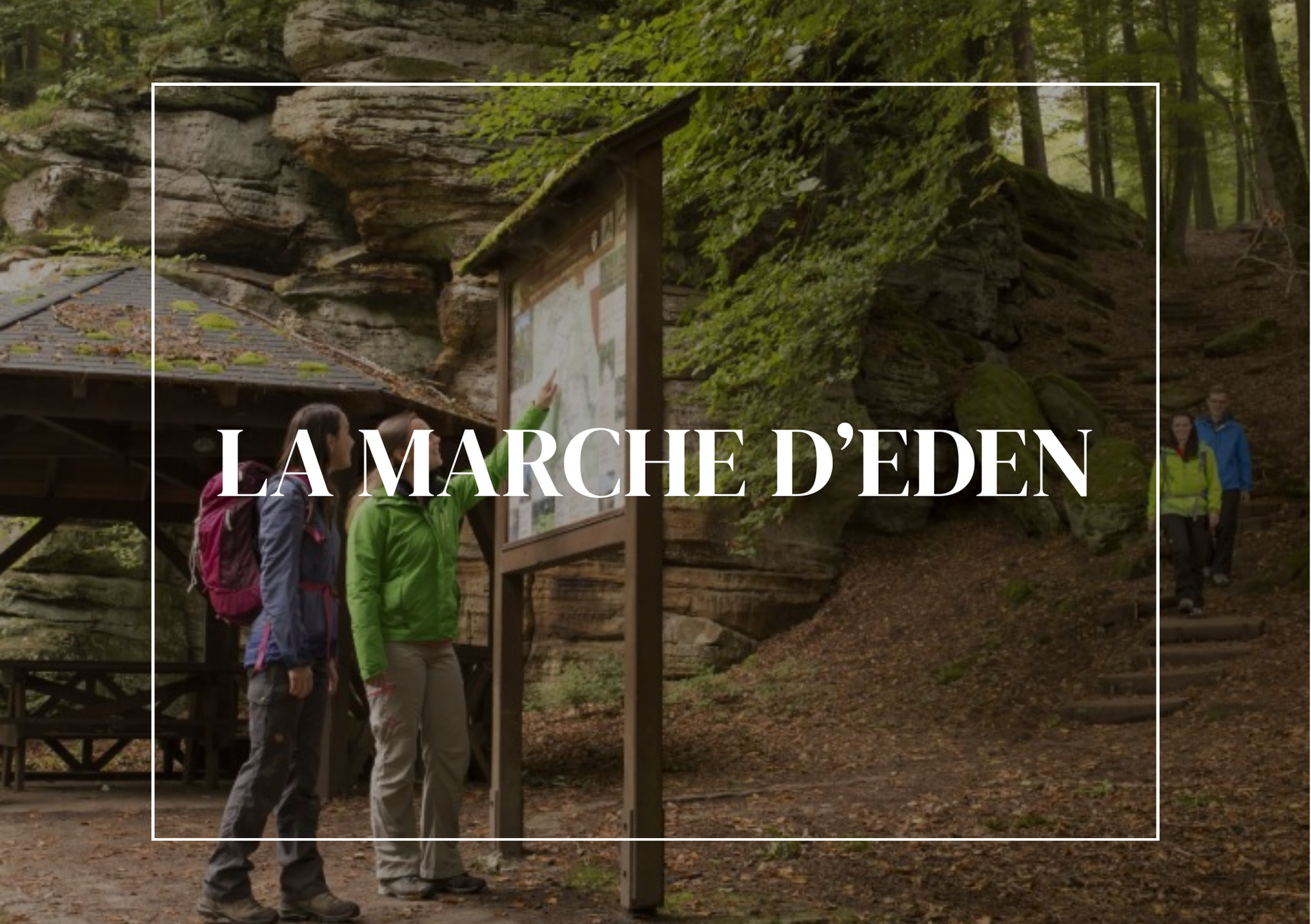 Des gens regardent une carte sur un panneau, dans une forêt, intitulé « La Marche d'Eden ».