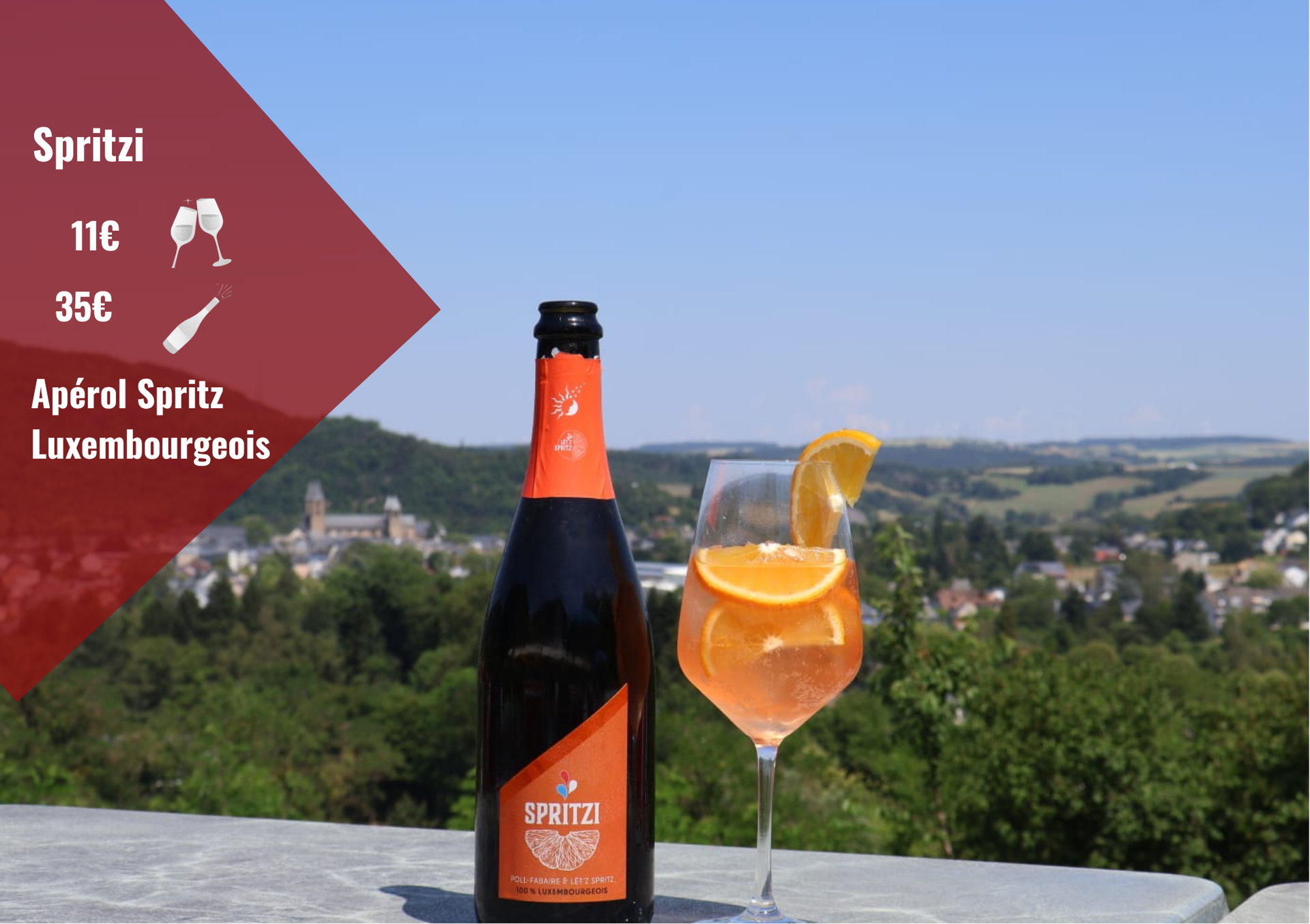 Bouteille d'Aperol Spritz et cocktail posés sur un rebord offrant une vue panoramique sur la colline.