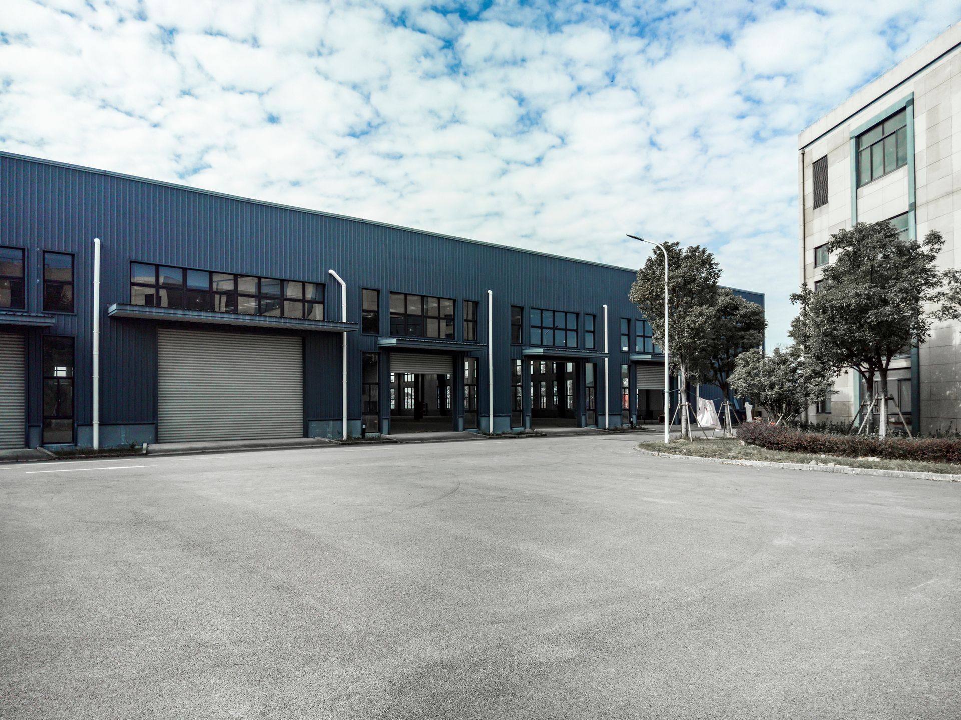 Empty parking lot next to outdoor warehouse built by a commercial building contractor
