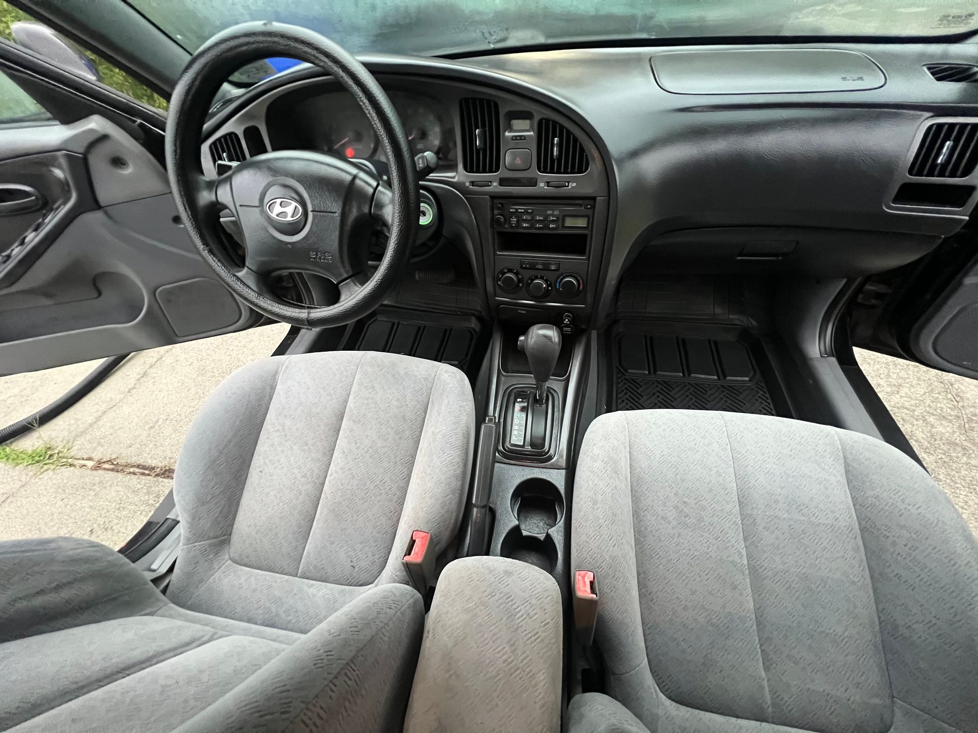Car interior with gray cloth seats, black dashboard, and center console view from the front seats