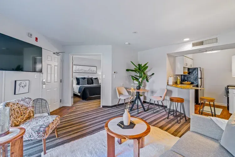 A living room with a couch , chair , table and television.