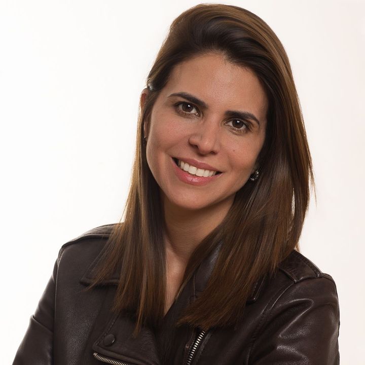 Smiling woman in a dark leather jacket against a white background
