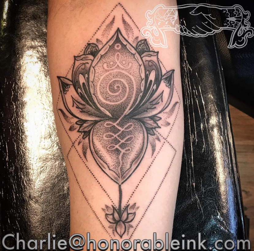 Black and gray lotus mandala tattoo with spiral center on skin
