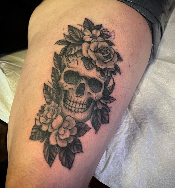 Black-and-gray skull tattoo with roses on a forearm