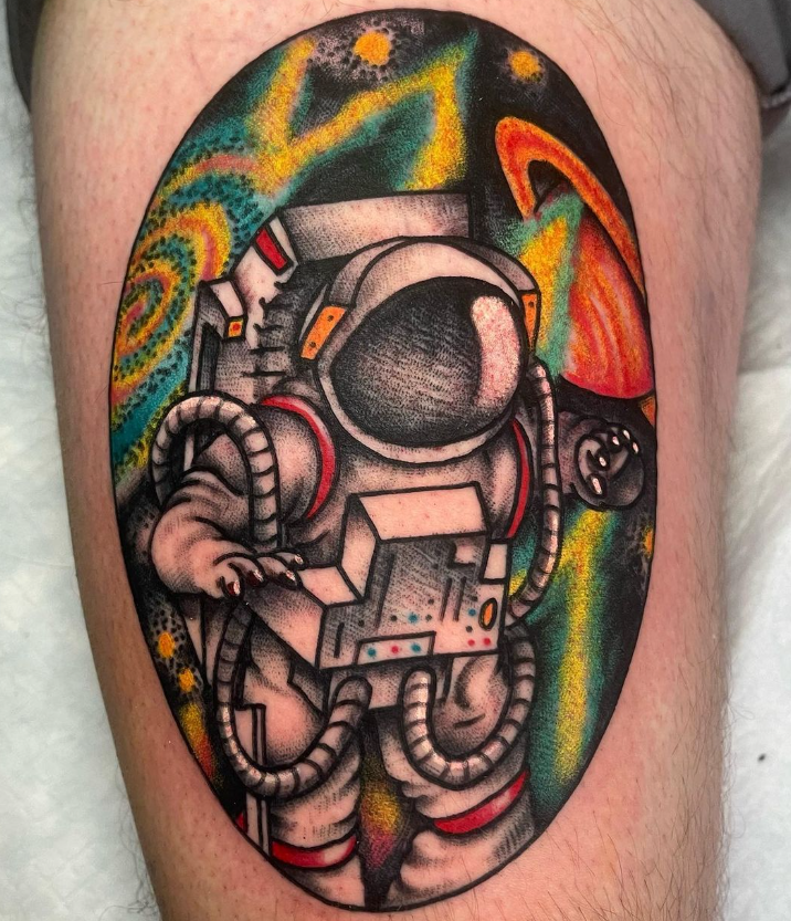 Colorful astronaut tattoo on skin with orange, green, and black swirling background