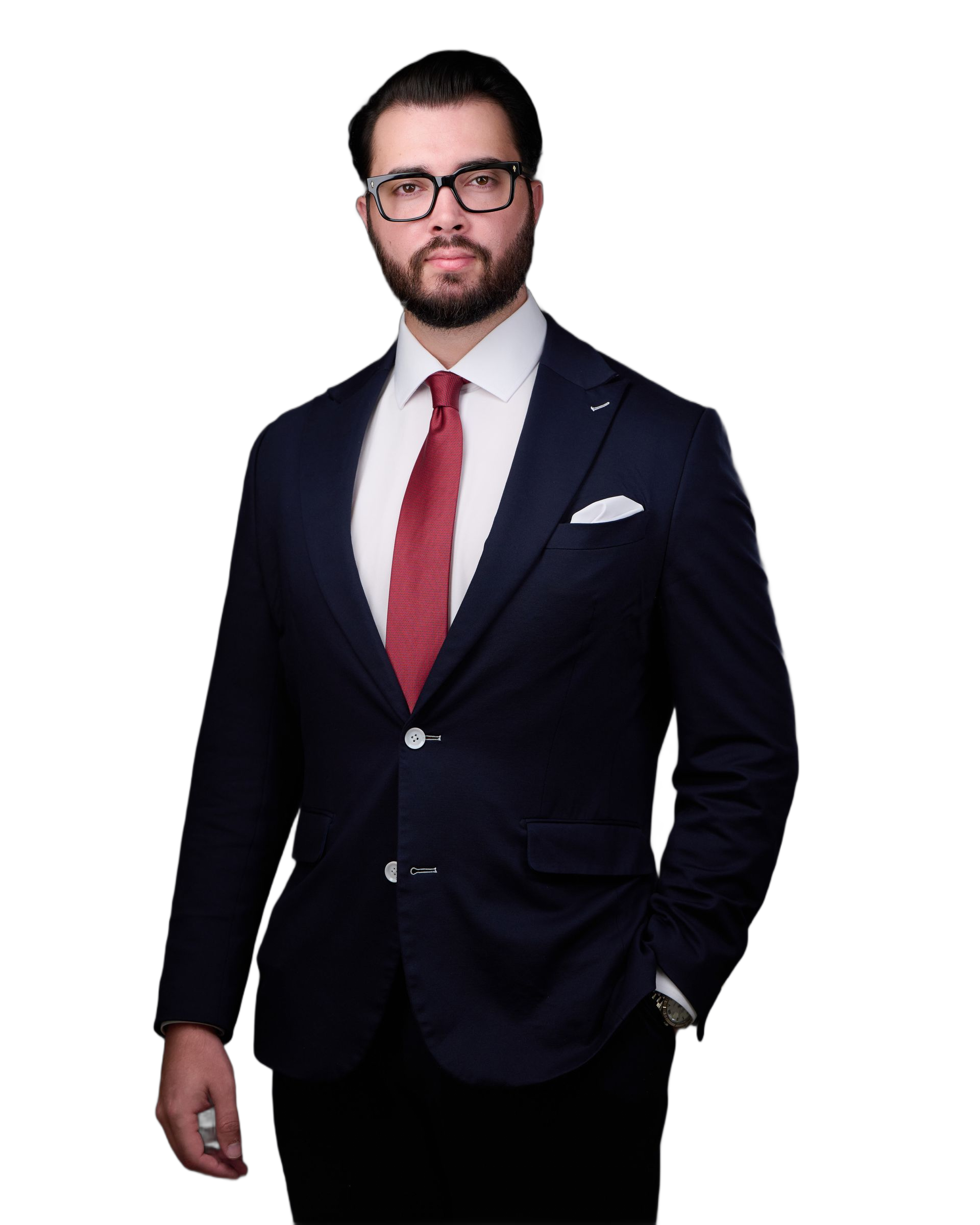 Man in a navy suit with red tie and glasses, smiling, white pocket square.