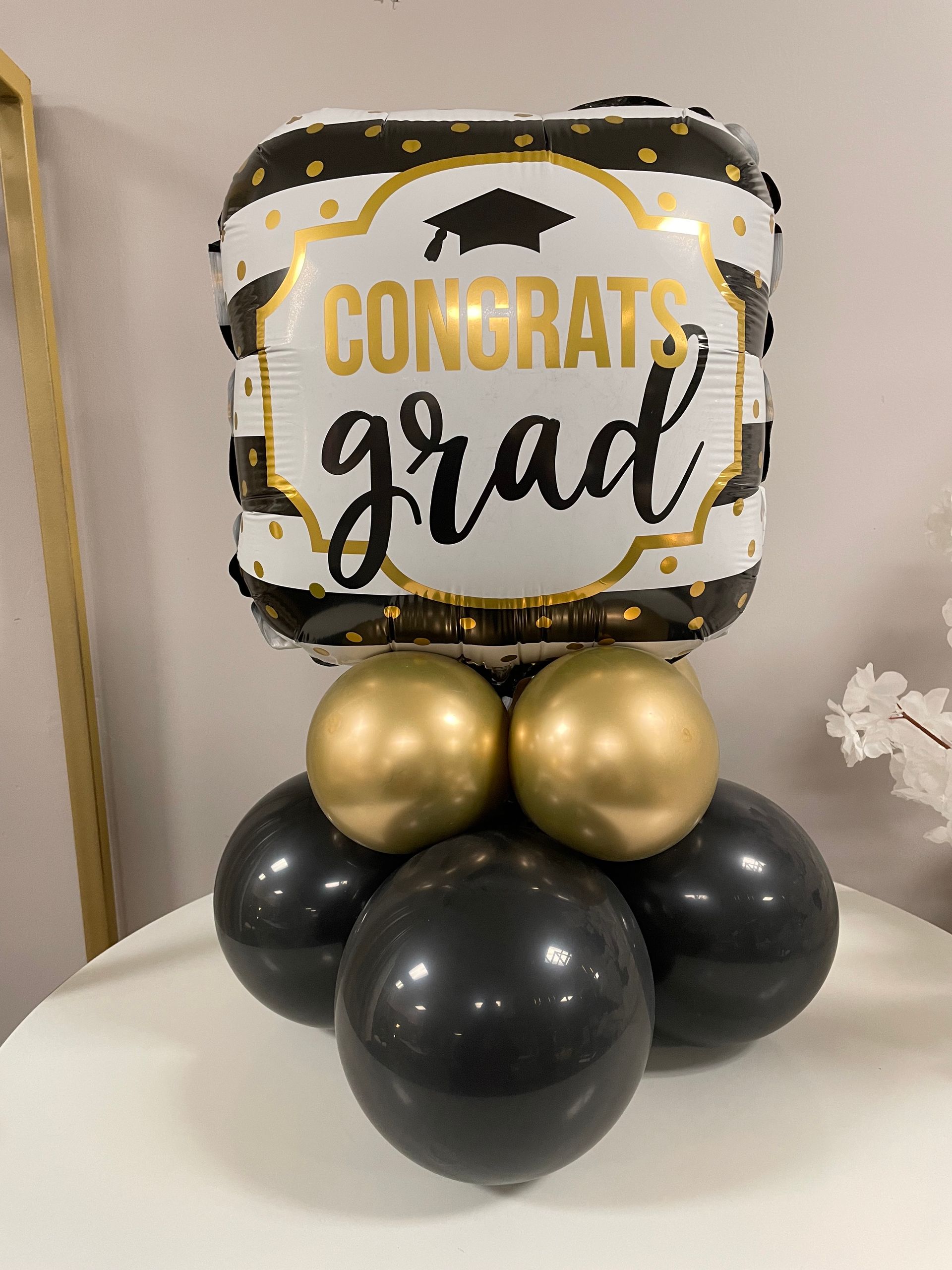 Congrats grad themed foil balloon sign for a graduation celebration