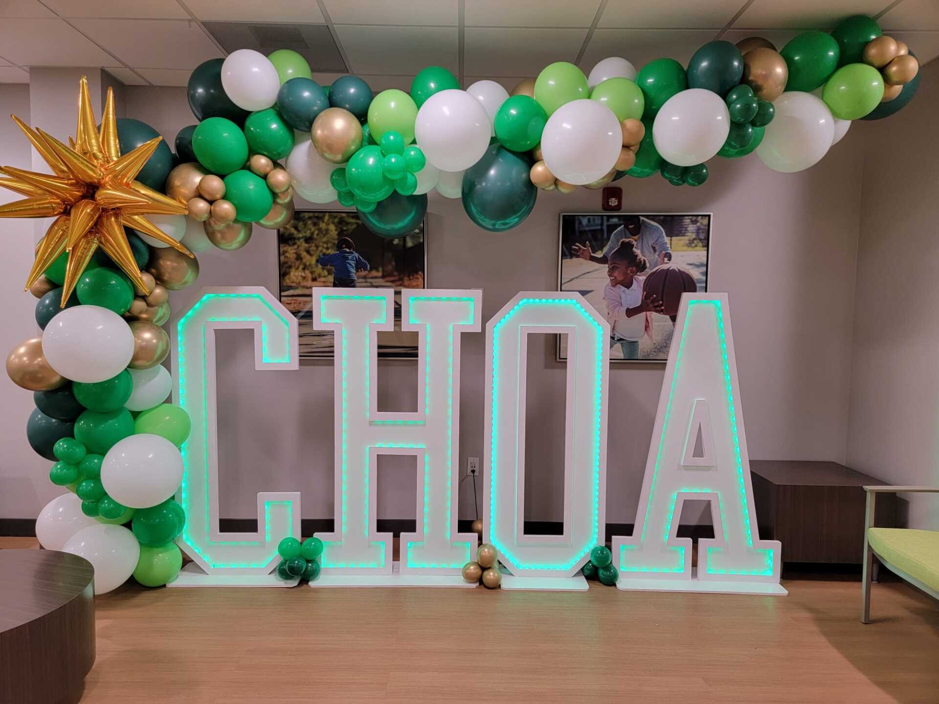 Personalized marquee letters with green white and gold balloon installation for hospital 