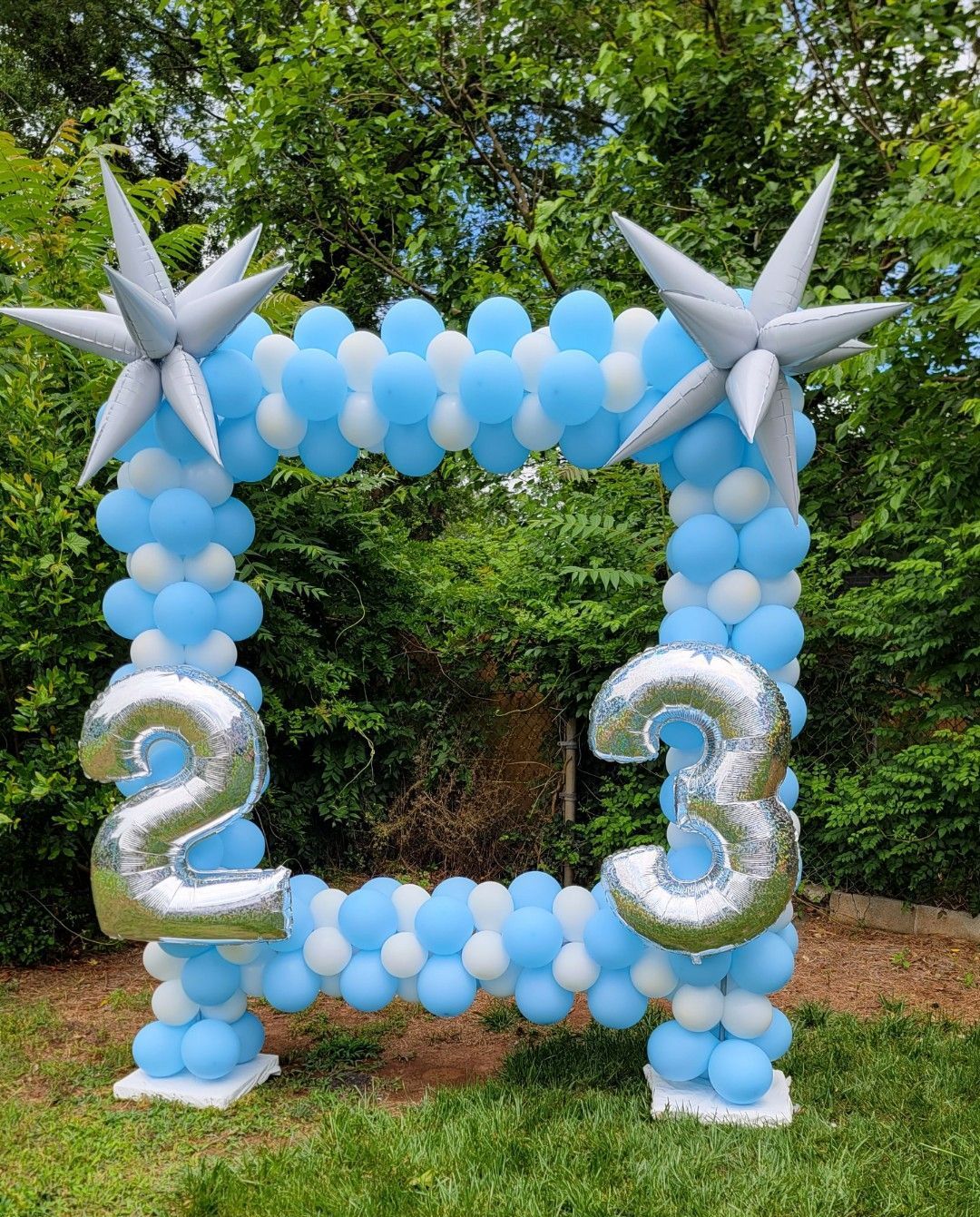Outdoor blue balloon arch with silver star balloons for entrance décor at birthday or celebration event