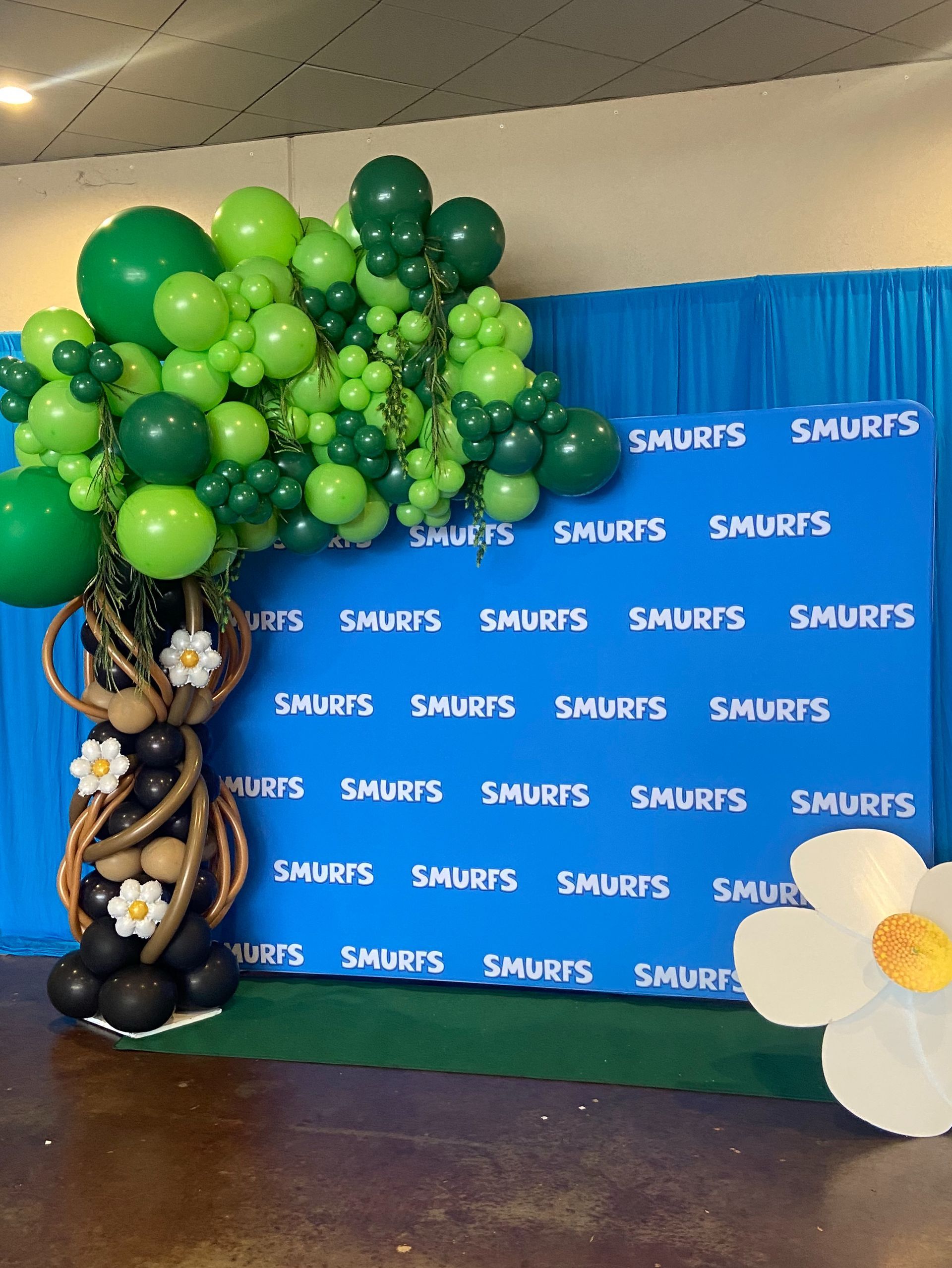 Green organic balloon installation with layered shades for themed kids party backdrop