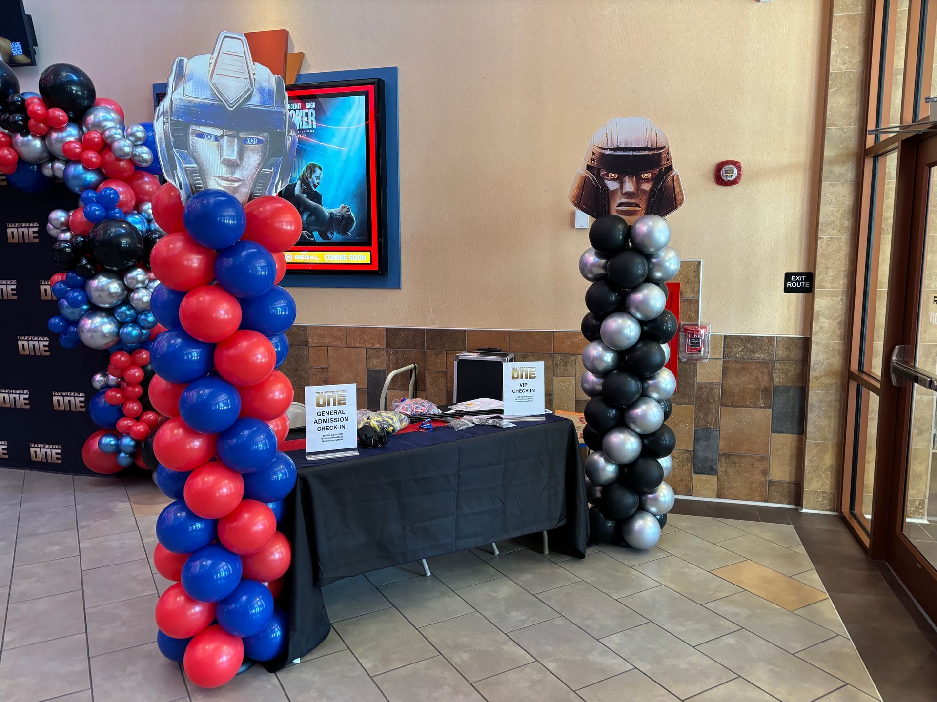 Red, blue, and black balloon arch and columns decorating a themed event entrance table