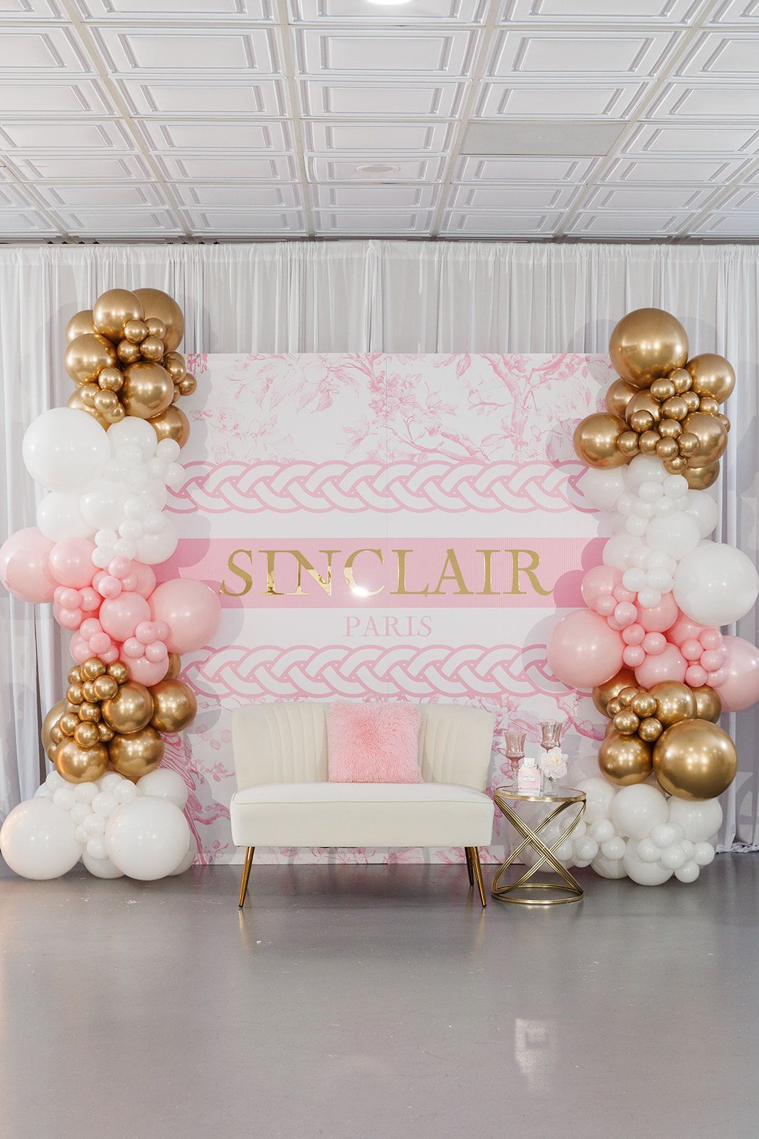 White curtain backdrop with gold and ivory balloon arrangement for elegant event décor