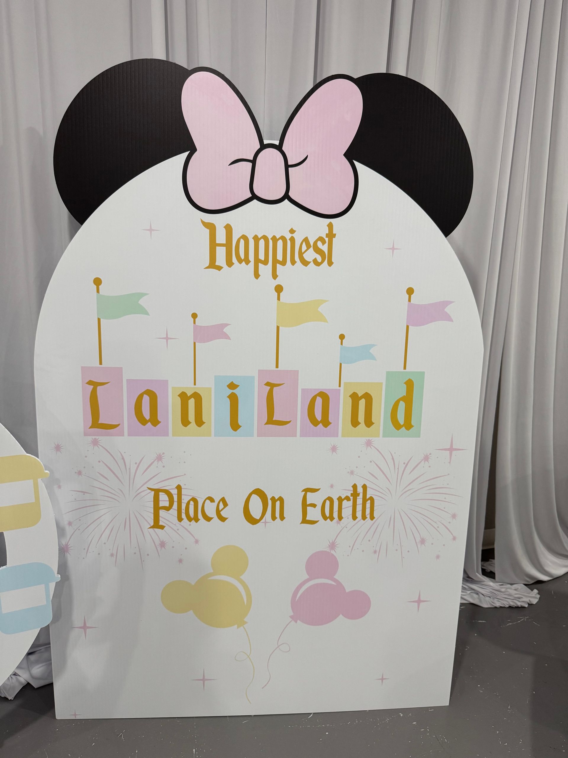 Minnie Mouse inspired round backdrop with bow and “Happiest” sign for pastel kids birthday party decor