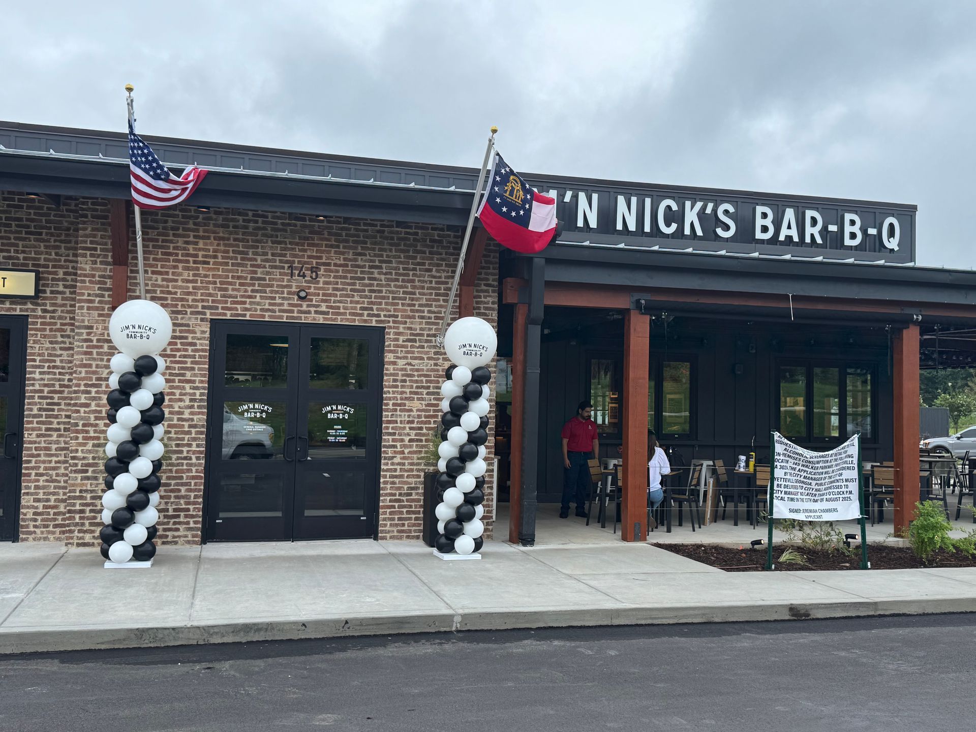 Black and white balloon columns decorating the entrance of a restaurant for an outdoor event