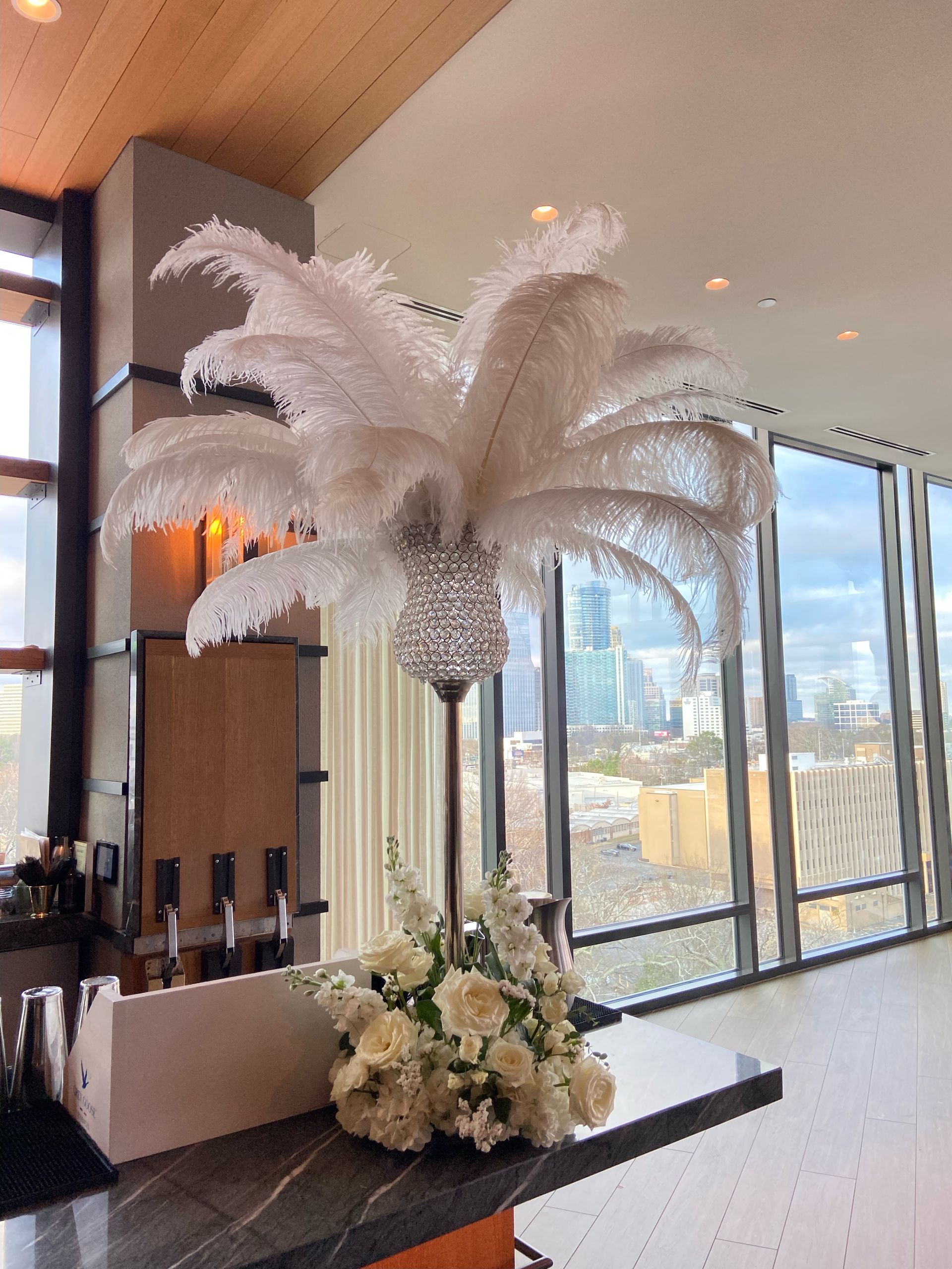 Tall white feather centerpiece arrangement for glamorous event or reception table décor