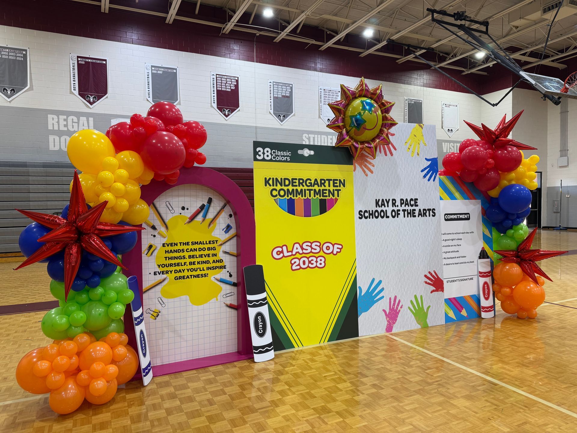 School themed backdrop with bright balloon clusters and classroom decor props for kindergarten graduation or school event