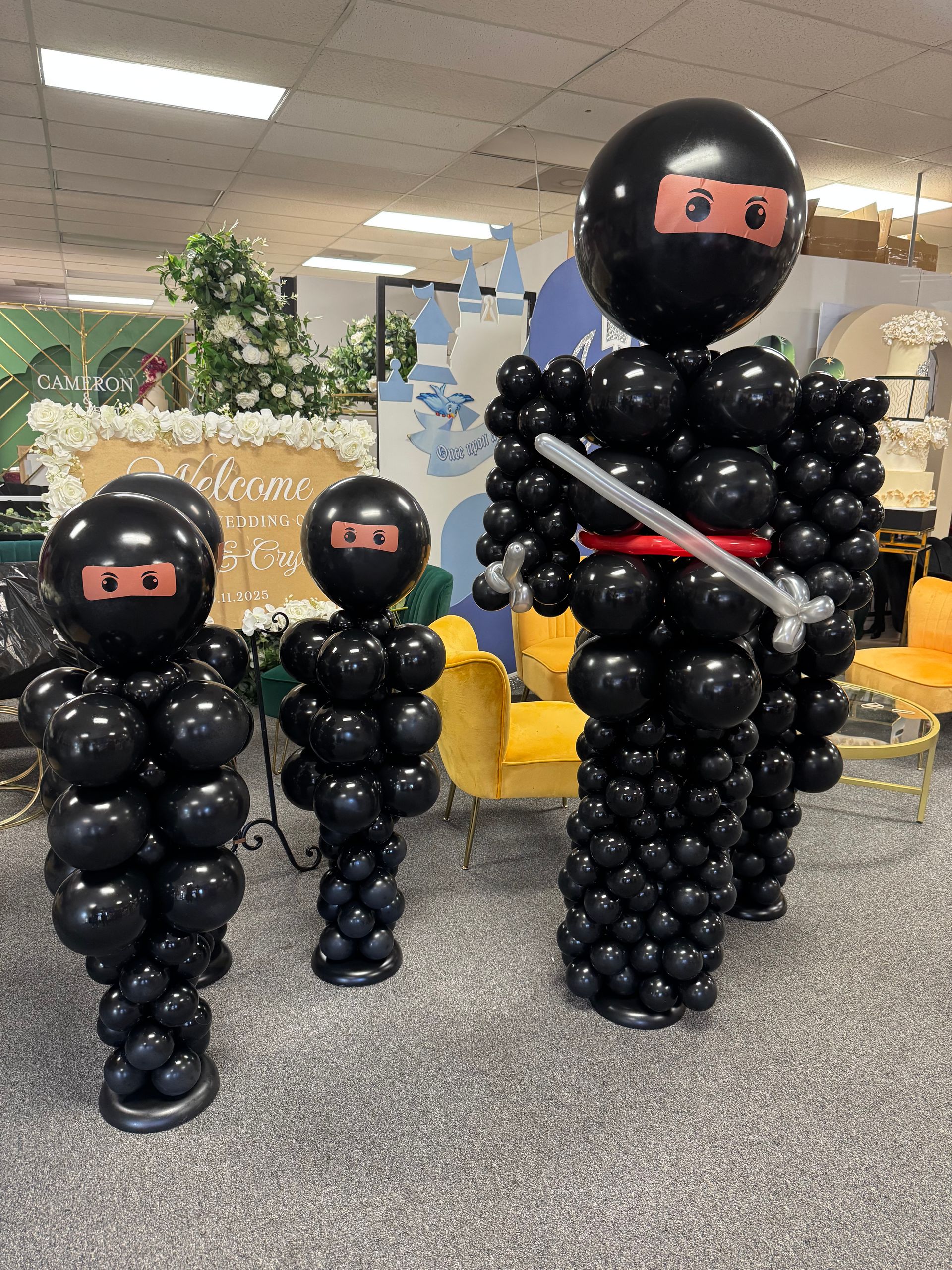 Black ninja-themed balloon sculptures and columns for a children’s birthday party setup