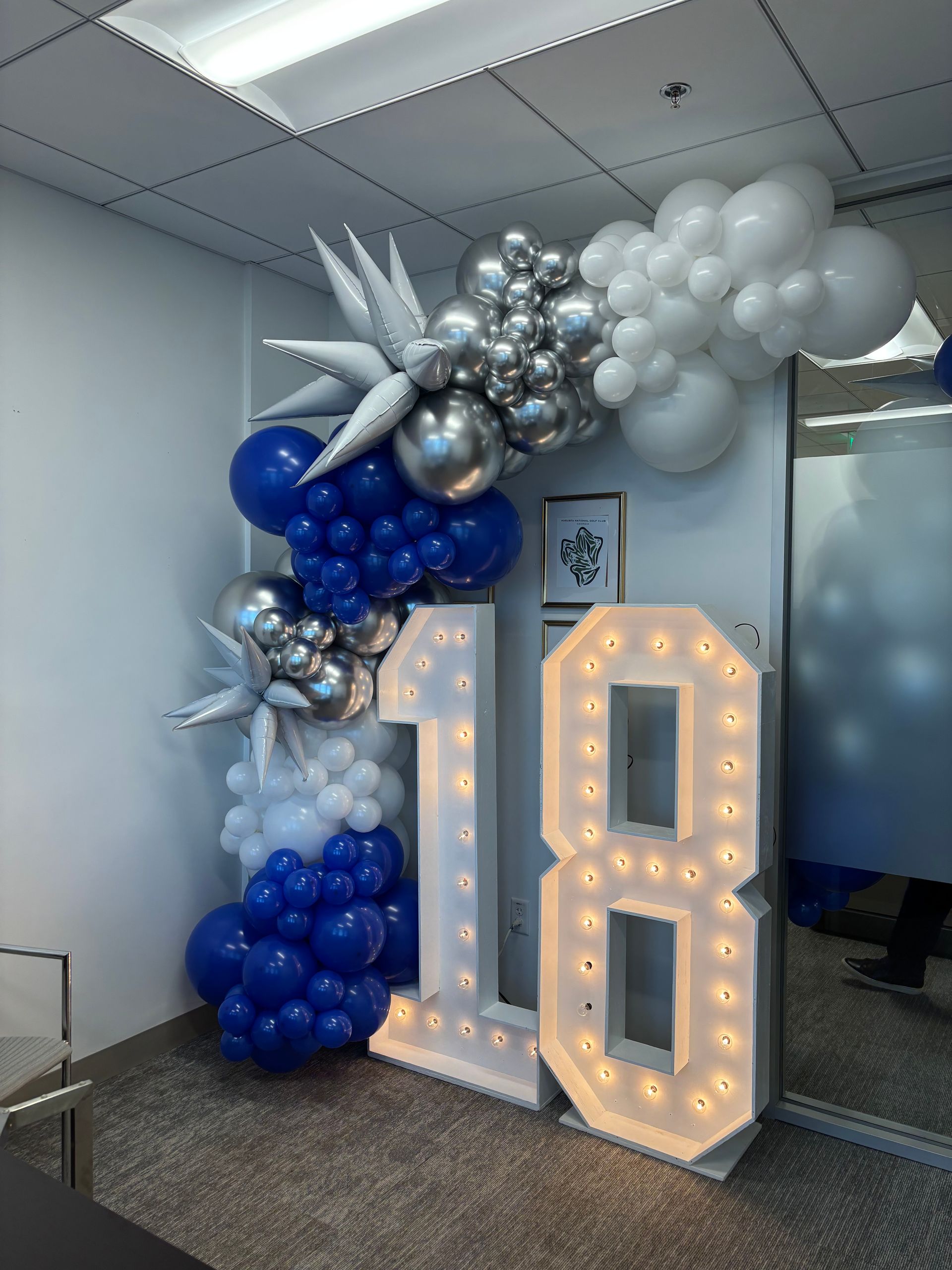 Modern balloon garland with silver white and blue balloons and star accents for indoor celebration